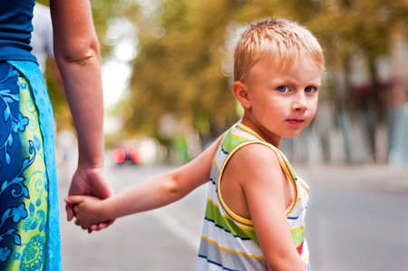 The child holds mum by the handの写真素材