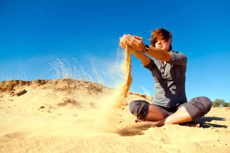 Woman playing with sand and windの写真素材