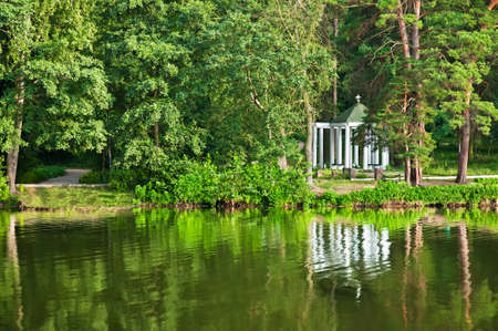 Religious monument near lake among wood 