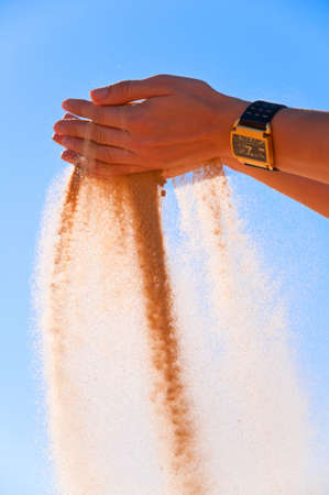 A young woman pouring sand from the handsの写真素材