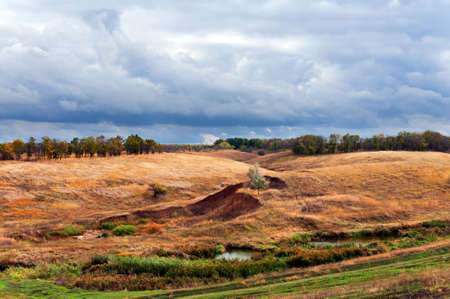 The narrow river flows among hills and woodsの写真素材