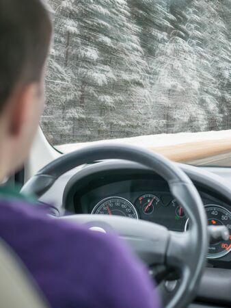 Snowy Asphalt Road leading through a snowy forest. Shallow DOF, focus on dashboard