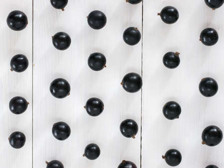 Fresh black currants on white wooden background. blackcurrants pattern for wallpaper. Flay lay or top viewの写真素材