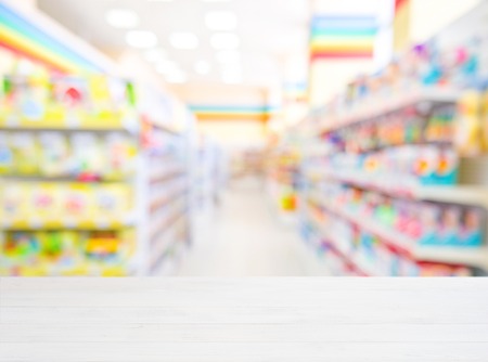 White wooden board empty table in front of blurred background. Perspective white wood over blur in kids toys store - can be used for display or montage your products. Mockup for display of product.の写真素材