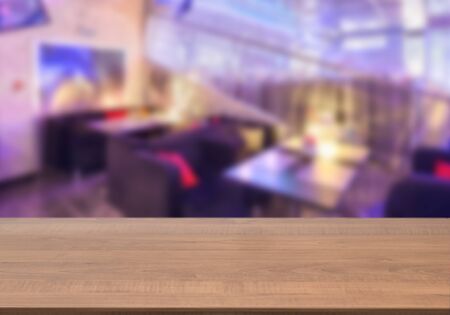 Dark wooden board empty table in front of blurred background. Perspective brown wood over blur in...