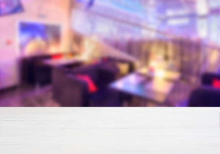 White ooden board empty table in front of blurred background. Perspective whitewood over blur in cafe interior - can be used for display or montage your products. Mockup your productsの写真素材