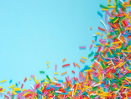 Border frame of colorful sprinkles on blue backgroundの写真素材