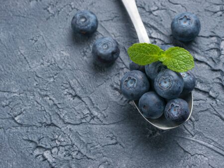 Blueberries in spoon on dark backgroundの写真素材