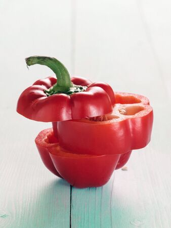 Sweet red peppers sliced on blue wooden background