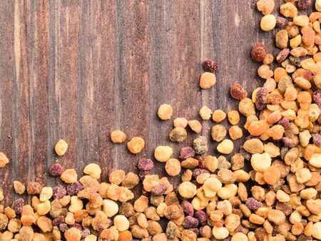 Closeup view of bee pollen on brown wooden table