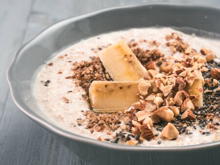 Overnight oats in bowl and ingredients on gray wooden tableの写真素材