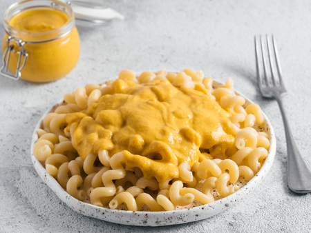 Pasta with vegan creamy chia cheddar sauce on gray background. Ideas and recipe for healthy diet or vegan food. Dish with homemade plant based Chia Cheeze Sauce. Copy spaceの写真素材