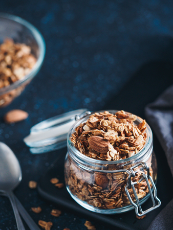 Homemade granola in glass jar on dark tableの写真素材