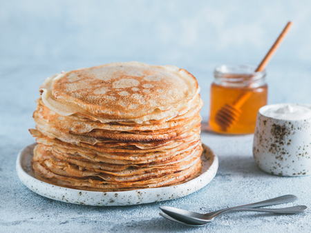 Stack of traditional russian pancakes blini on gray background with copy space. Homemade russian thin pancakes blini. Russian food, russian kitchenの写真素材
