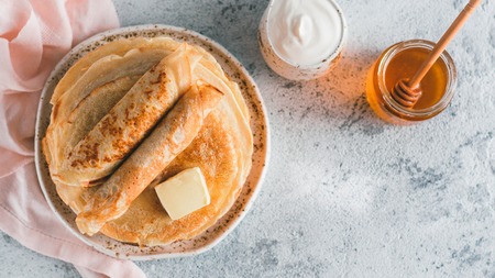 Stack of traditional russian pancakes blini on gray background with copy space. Homemade russian thin pancakes blini. Russian food, russian kitchen. Top view or flat layの写真素材