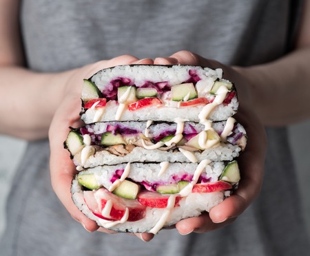 Vegan sushi sandwich onigirazu with mushrooms and vegetables.Healthy dinner recipe and idea. Colorful japan big roll sandwich onigirazu with red cabbage,radish,cucumber,mushrooms.Trend food.Copy spaceの写真素材