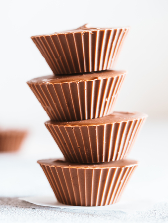 Stack of vegan chocolate cups with caramel on whiteの写真素材