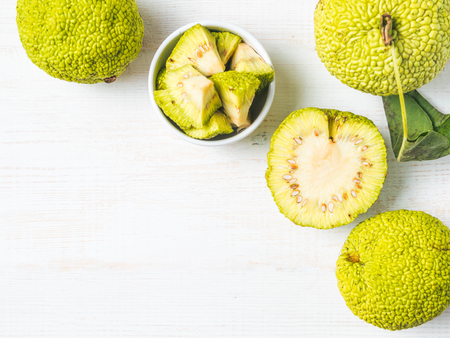 Green fruit of maclura pomifera,osage orange,horse apple,adam apple grow on white wooden table....