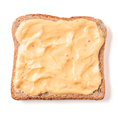 Bread slice with mustard sauce isolated on whiteの写真素材
