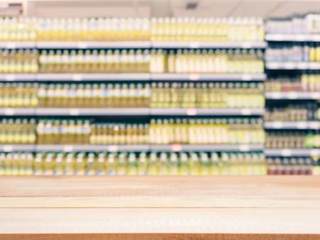 Light wooden board empty table in front of blurred background. Perspective table over blur in supermarket - can be used for display or montage your products. Mockup for display of product.の写真素材
