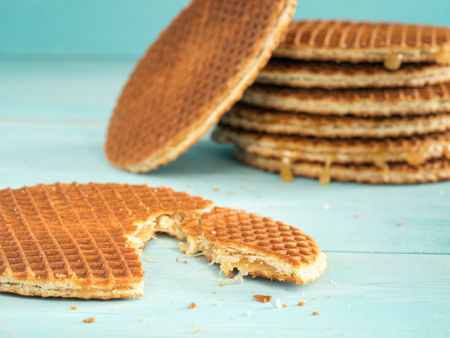 Stroopwafels or caramel Dutch Waffle close up on turquoise wooden backgroundの写真素材