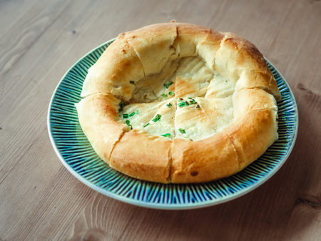 tasty tandoor baked bread on plate. National asian bread - tandoor bread with green onion on wooden...