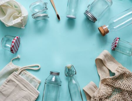 Zero waste concept. Textile eco bags, glass jars and bamboo toothbrush on blue background with copy space for text in center. Eco friendly and reuse concept. Top view or flat layの写真素材