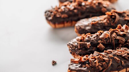 Set of homemade eclairs with chocolate on marble background. Close up view of delicious healthy...