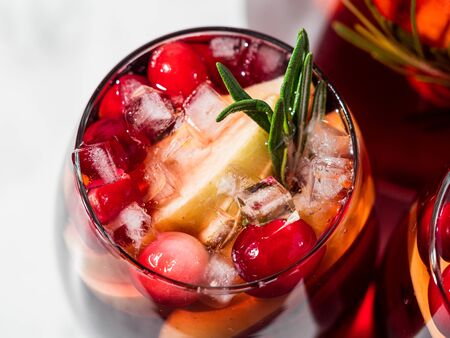 Winter sangria on tabletop with gray linen tablecloth. Glasses of sangria with fruit slice, cranberry and rosemary. Copy space for text or design. Horizontal. Top view or flat lay.の写真素材