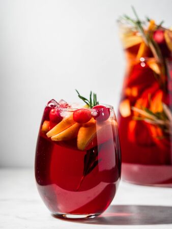 Winter sangria on tabletop. Glasses of sangria with fruit slice, cranberry and rosemary. Vertical. Copy space for text or design.の写真素材