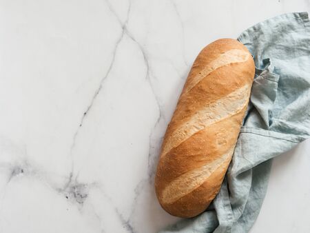 British White Bloomer or European Baton loaf bread on white marble background. Top view or flat lay. Copy space for text or design.の写真素材