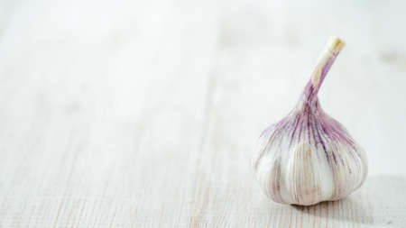 Garlic bulb on white wooden background. Perfect head of garlic with copy space for text or design. Horizontalの写真素材