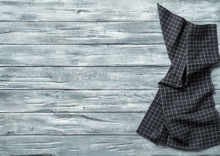 Gray wooden table with balck and white dark linen kitchen towel or textile napkin flat lay. Dark...