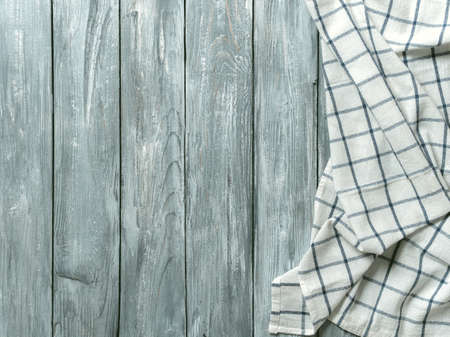 Gray wooden table with linen kitchen towel or textile napkin flat lay. Blue tablecloth on old gray...