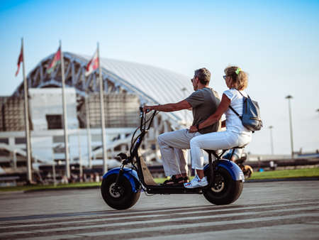 Man and woman on two-seater electric scooterのeditorial素材