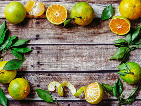 Green mandarins on wooden background, top viewの写真素材