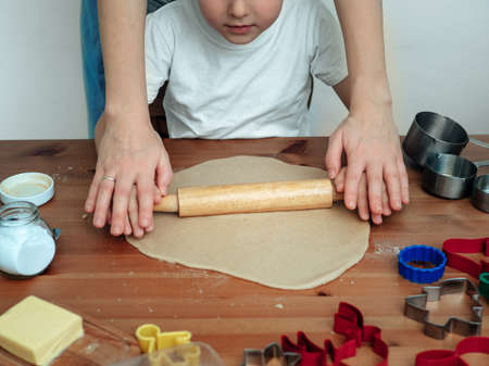 Young mother and son in kitchen making cookiesの写真素材