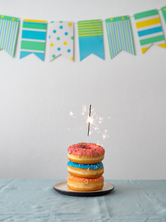 Birthday donuts cake with sparkler on tableの写真素材