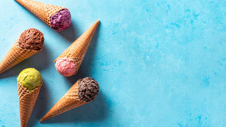 ice cream scoops in cones with copy space on blueの写真素材