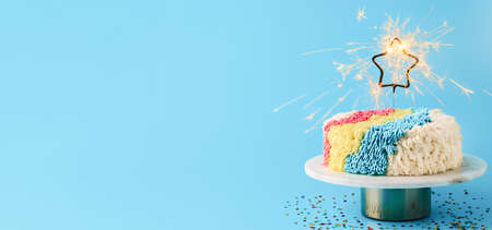 Shag cake with sparkler on blue, copy space