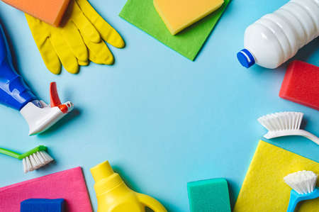House cleaning product on blue background, copy space. Flat lay or top view. Cleaning service or...