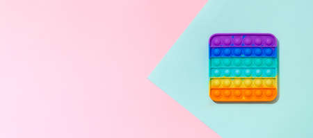 blue and pink background with copy space. Popular silicone colorful anti stress  toy for child. Top view from above. Simple dimple. Horizontal bannerの写真素材