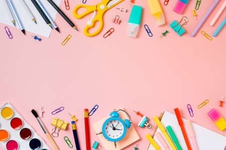 Creative student desk with school supplies and copy space in center. Top view or flat lay. Trendy back to school flat lay on pink backgroundの写真素材