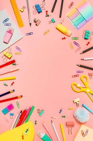 Creative student desk with school supplies and copy space in center. Top view or flat lay. Trendy back to school flat lay on pink background. Verticalの写真素材
