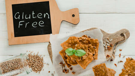 Gluten-freen crispbreads made of buskwheat flour. Green buckwheat flour smoked paprika sunflower seeds ingredients homemade baked crisp bread. Idea recipe snacks gluten free concept. Top view flat layの写真素材