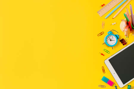 Back to school, online study, distantly learning class concept. Creative student desk with tablet pc and colorful modern school supplies on yellow background. Top view Flatlay. Copy spaceの写真素材