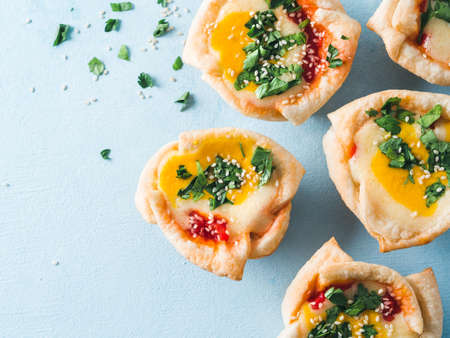 Ideas and recipes for healthy Vegan Shakshouka cups with vegan tofu eggs and turmeric yolk on blue...