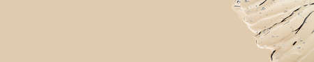 Liquid gel cosmetic smudge texture on one edge over neutral nude beige champagne background. Aesthetic beautiful textured smear transparent skin gel with oxygen bubbles. Copy space. Long horizontal bannerの写真素材