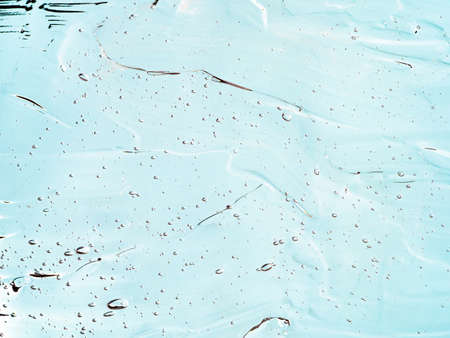 Liquid gel cosmetic texture on blue background. Aesthetic beautiful textured smears transparent skin gel. Top view or flat layの写真素材