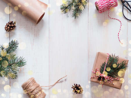 Christmas gift wrapping background, copy space. Zero waste gift wrapping. Craft paper and bokeh lights.. Winter holidays concept, flat lay or top view.の写真素材